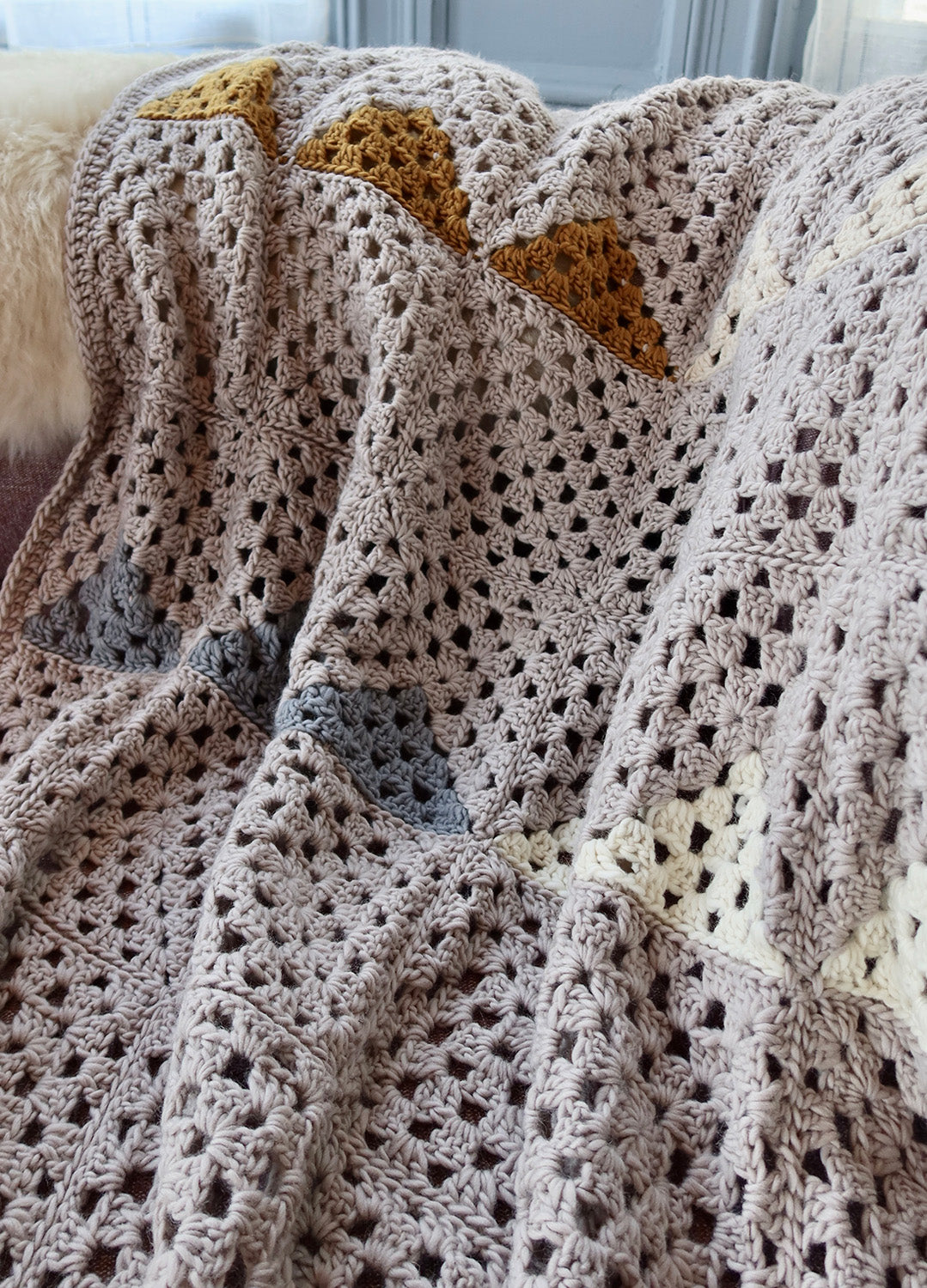 https://www.weareknitters.pl/cdn/shop/files/crochet-kit-petite-wool-landen_granny-square-blanket_en_02.jpg?v=1703103659&width=1500