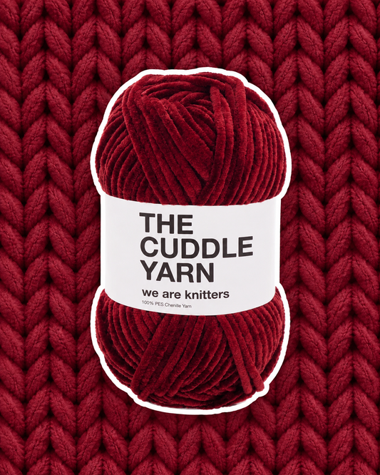 The Cuddle Yarn Red skein on matching knit background